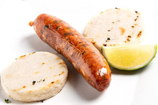 Arepas and chorizo on white background